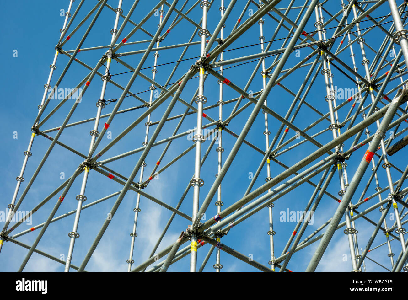 Metal pipe frame structure on blue sky background. Industrial