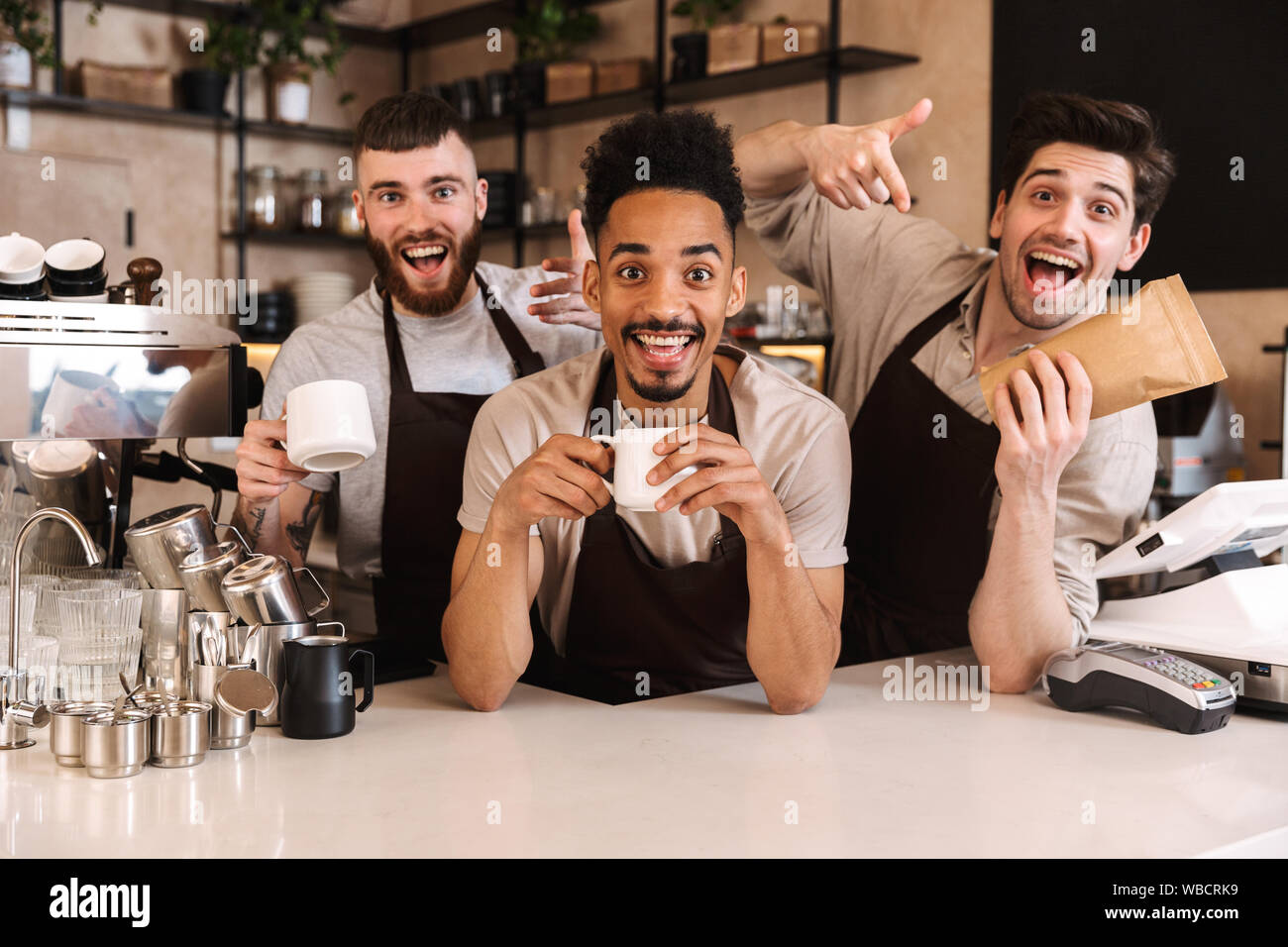 Smiling baristas standing counter in hi-res stock photography and ...