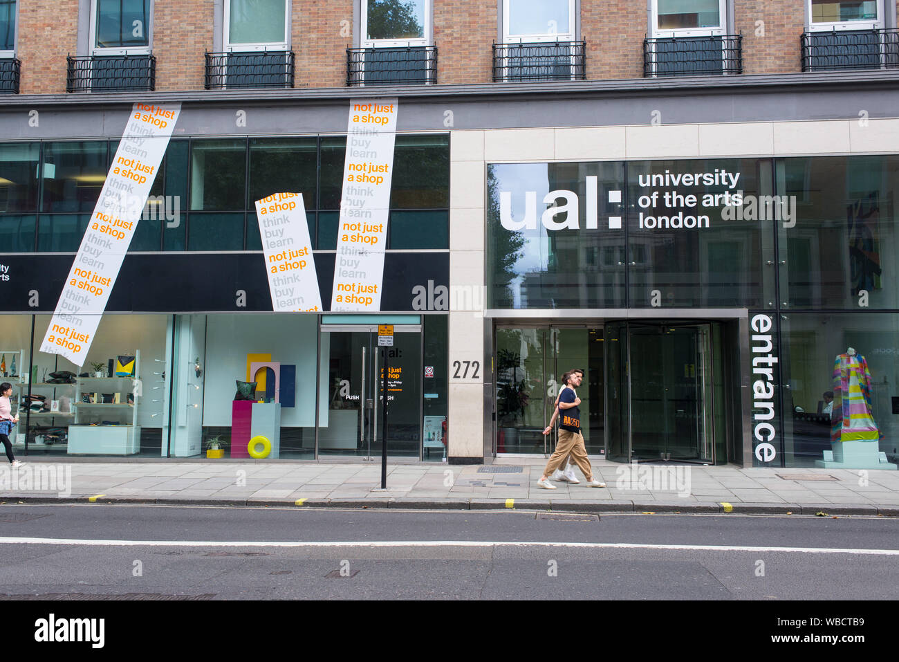 London, UK - August  2019: Men couple students walking in front of the main entrance of ual, University of the arts london, in High Holborn, London Stock Photo