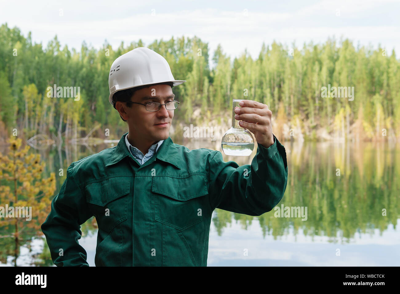 industrial ecologist or hydrologist visually evaluates the response of a water sample from lake at the site of a flooded mining pit Stock Photo