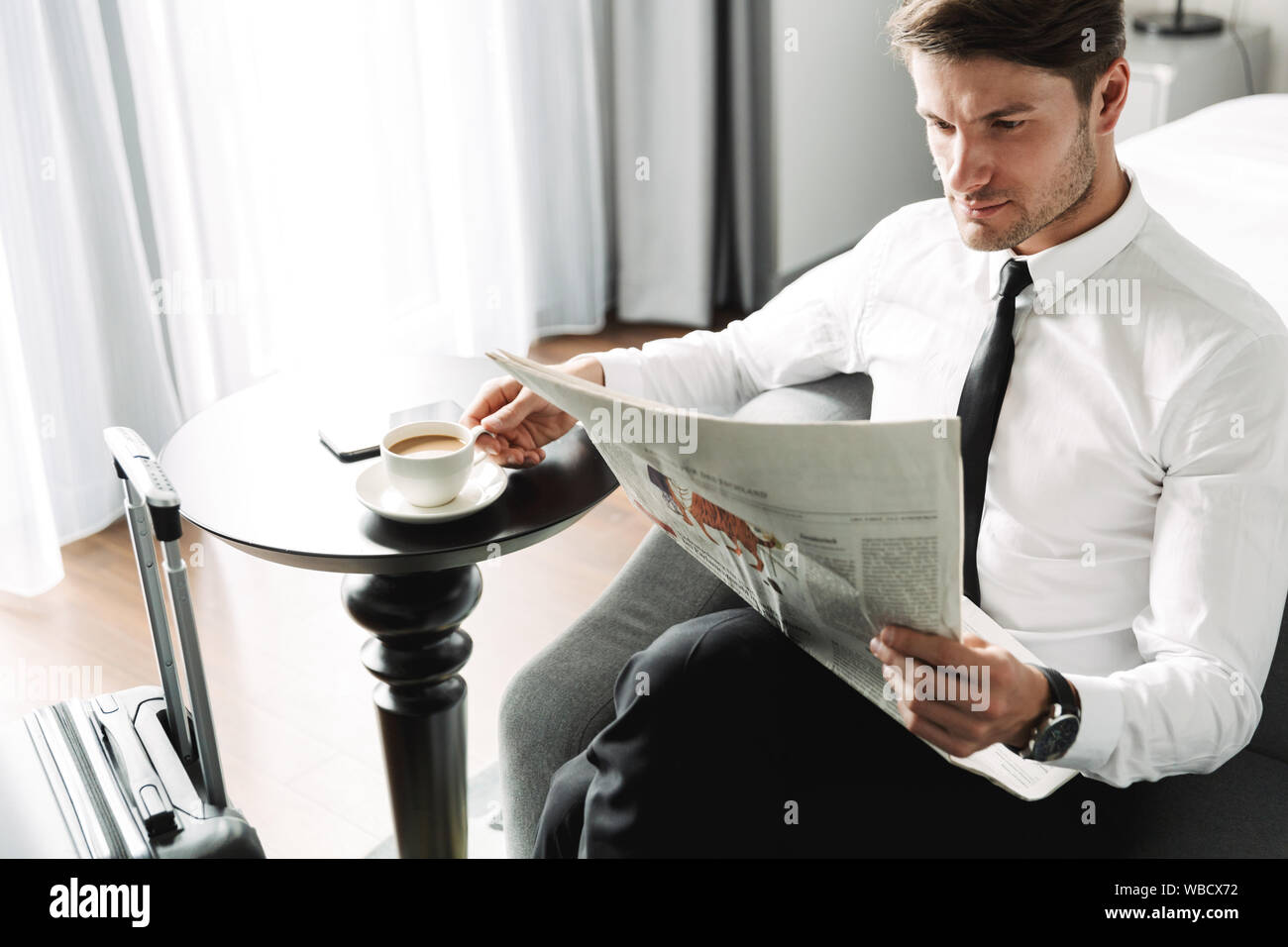Возвращение в кафе читать. Парень в костюме читает газету. Пьет кофе читает газету. Мужчина пьет кофе и читает газету. Мужчина деловой в костюме пьёт кофе.