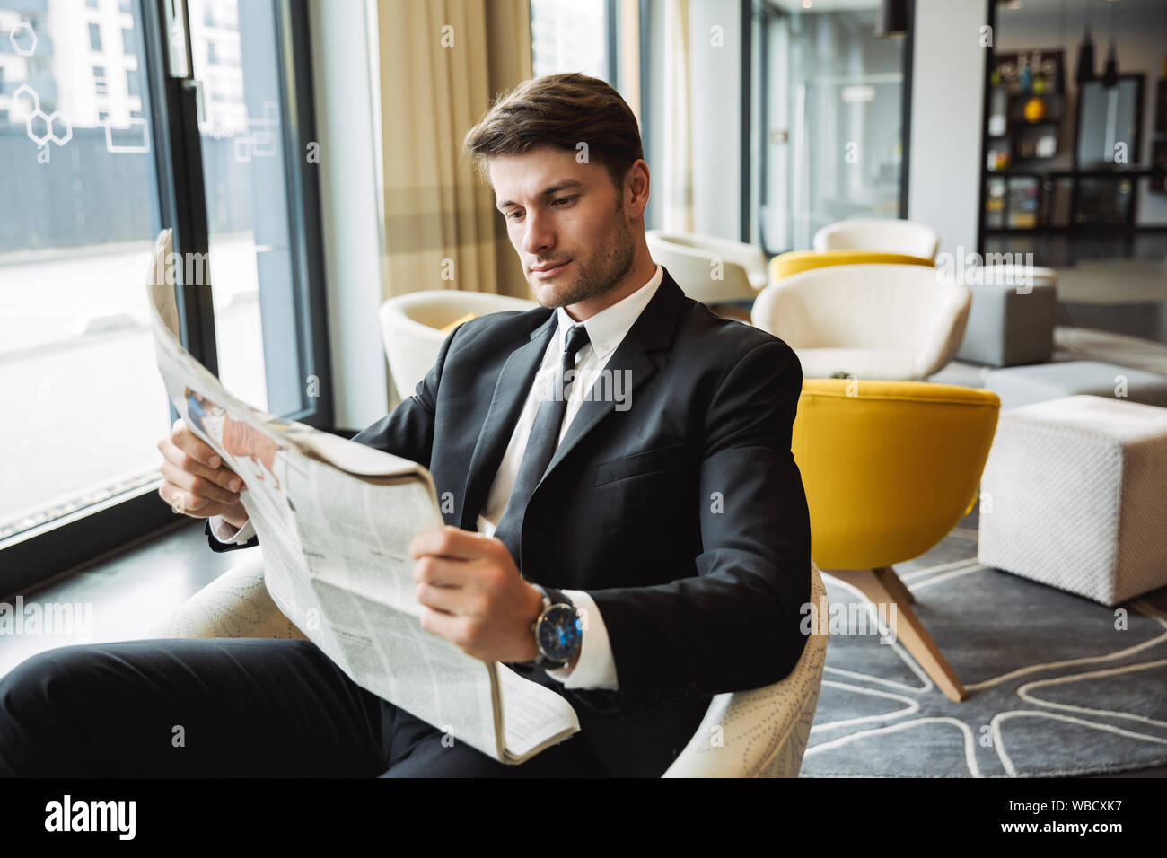 Portrait of confident young businessman wearing formal black suit ...