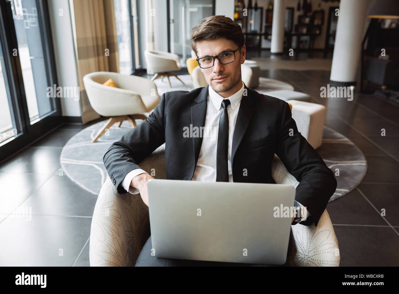 Photo of confident businessman wearing formal black suit and eyeglasses ...
