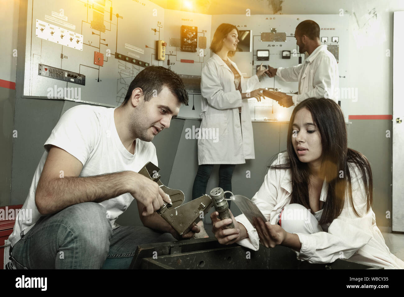 Group Inspecting Box Young friends solving conundrum in quest room in view as closed nuclear ...
