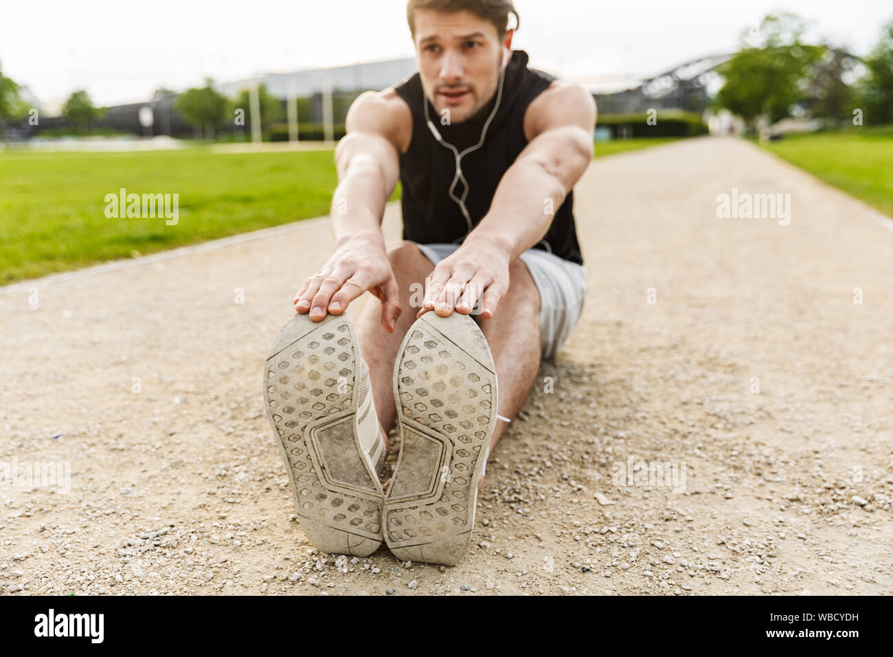 Photo of active man in sportswear working out with earphones and ...