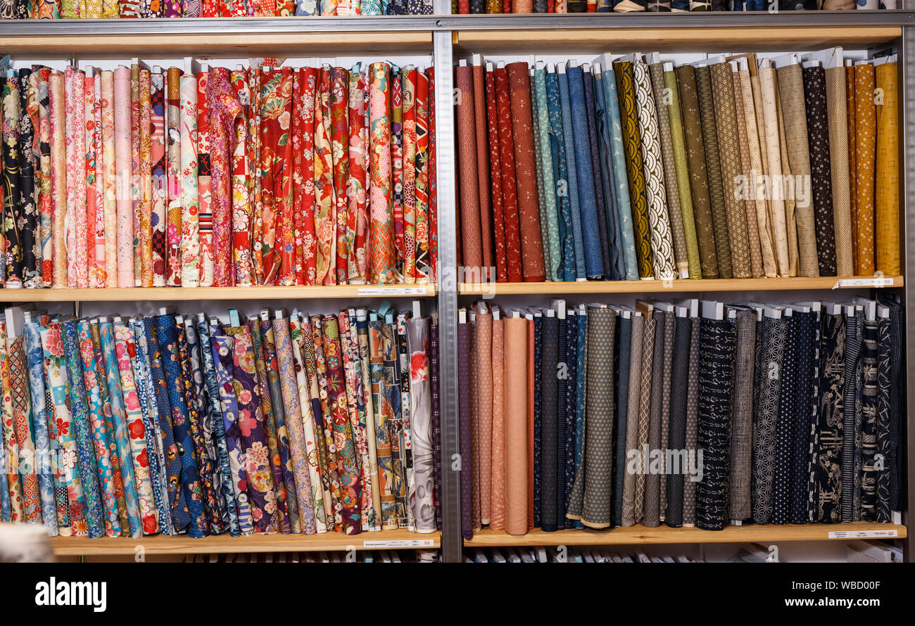 View of cloth rolls of different colors and patterns on shelves in ...