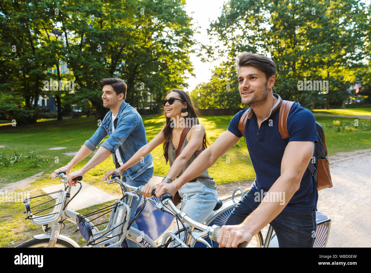 Group of happy cheerful friends riding bicycles at the park Stock Photo ...