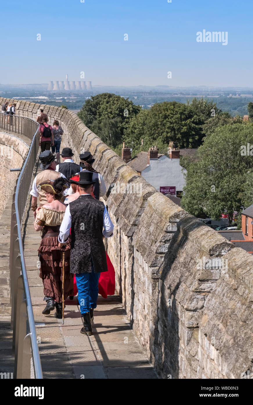 Visitors walking along the historic elevated walls of Lincoln Castle during the annual Lincoln Steampunk Festival, Lincolnshire, UK Stock Photo