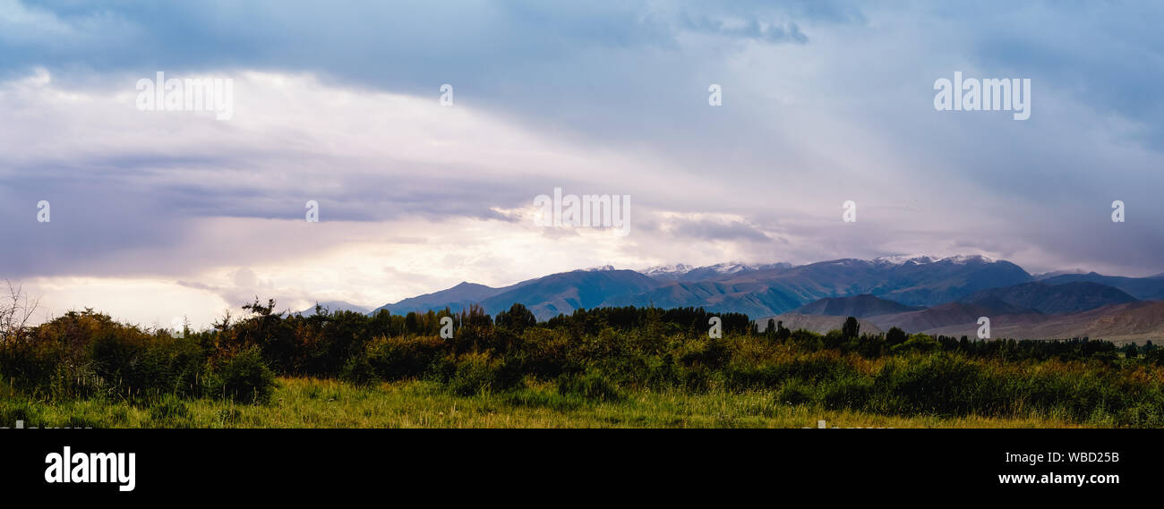 Panorama of a mountain valley in the summer. Amazing nature, mountains lit by sunset, summer in the mountains. Travel, tourism, beautiful background, Stock Photo