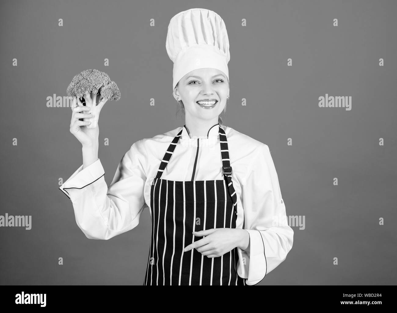 Including healthy organic foods in your life. Happy woman chef holding natural cabbage for healthy diet. Lady cook smiling with healthy green broccoli in hand. For a truly healthy and enjoyable dish. Stock Photo