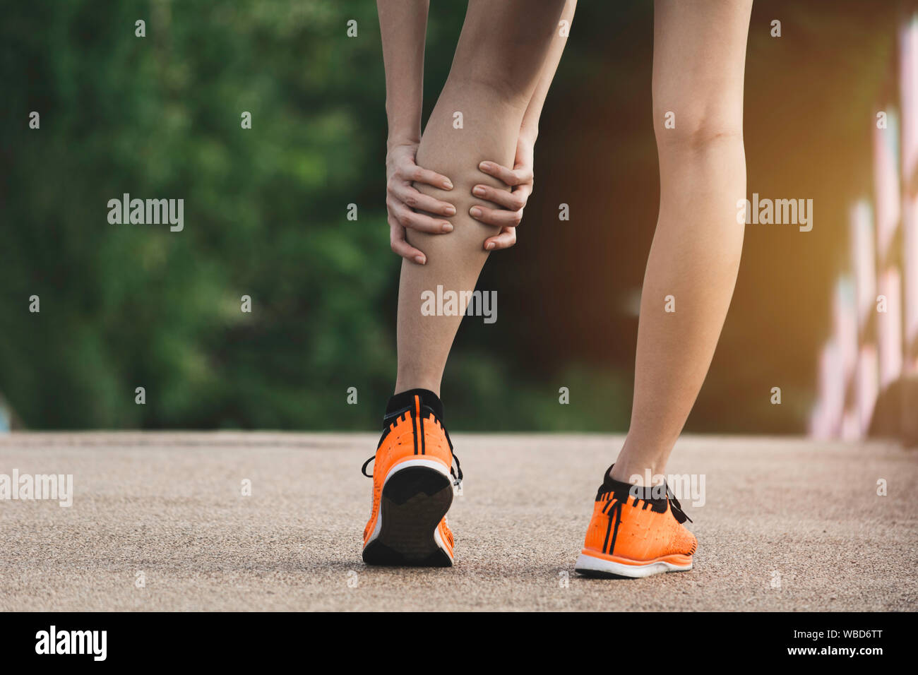 The female clings to a bad leg. The pain in her leg. Health and painful concept. Stock Photo