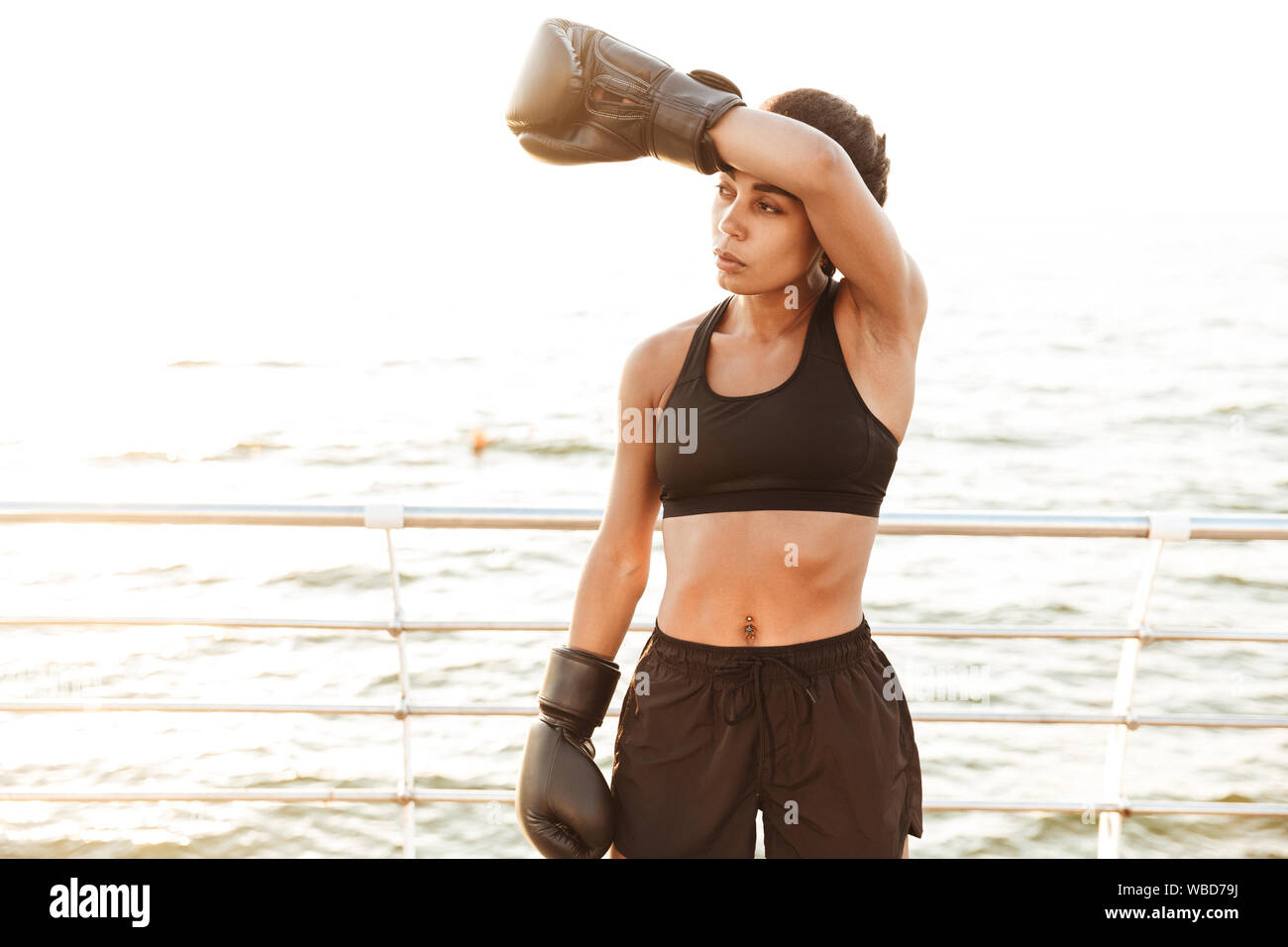 Image of strong pretty woman wearing sportive clothes training in