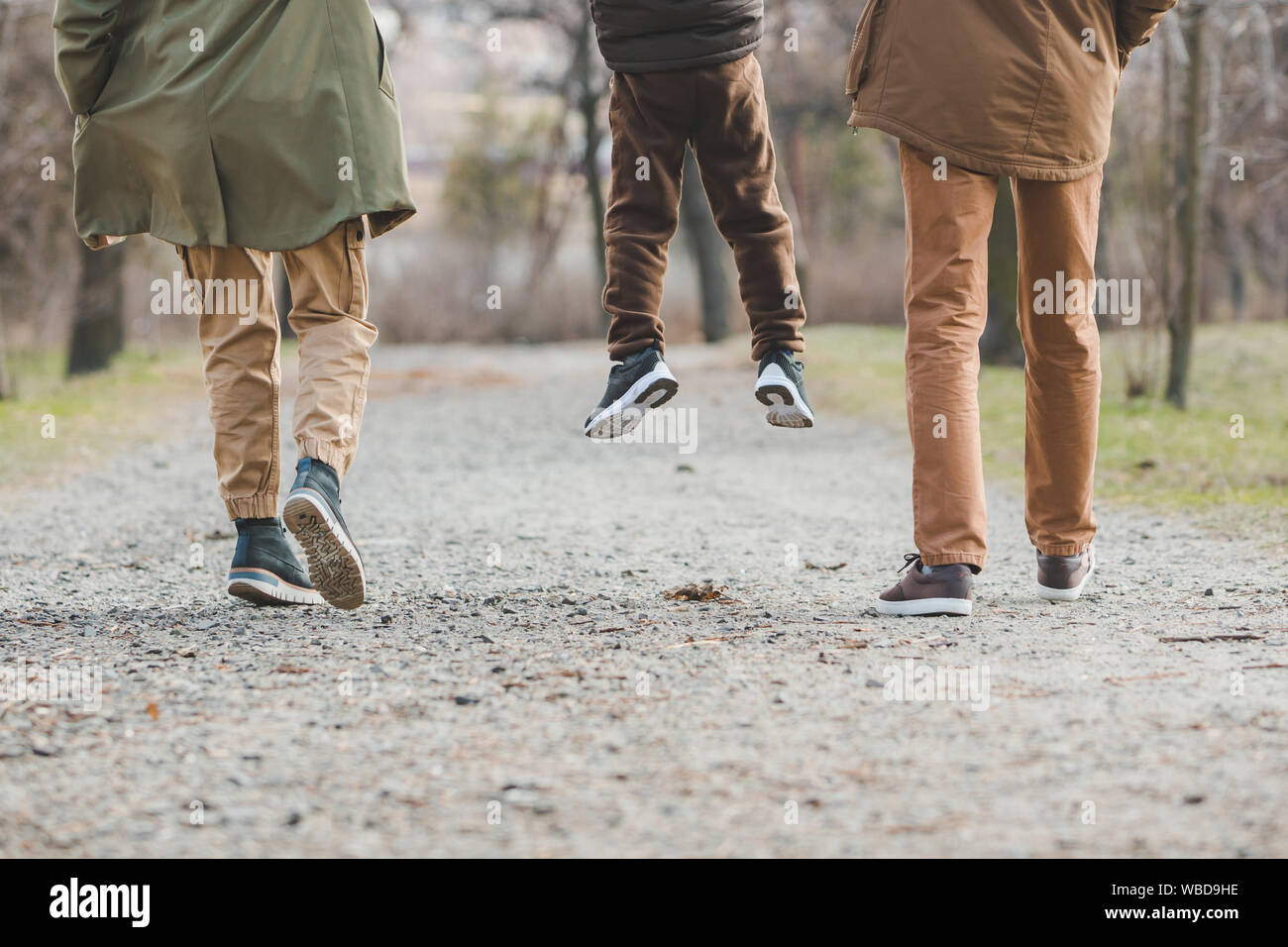 young beautiful family walking holding hands by city park Stock Photo