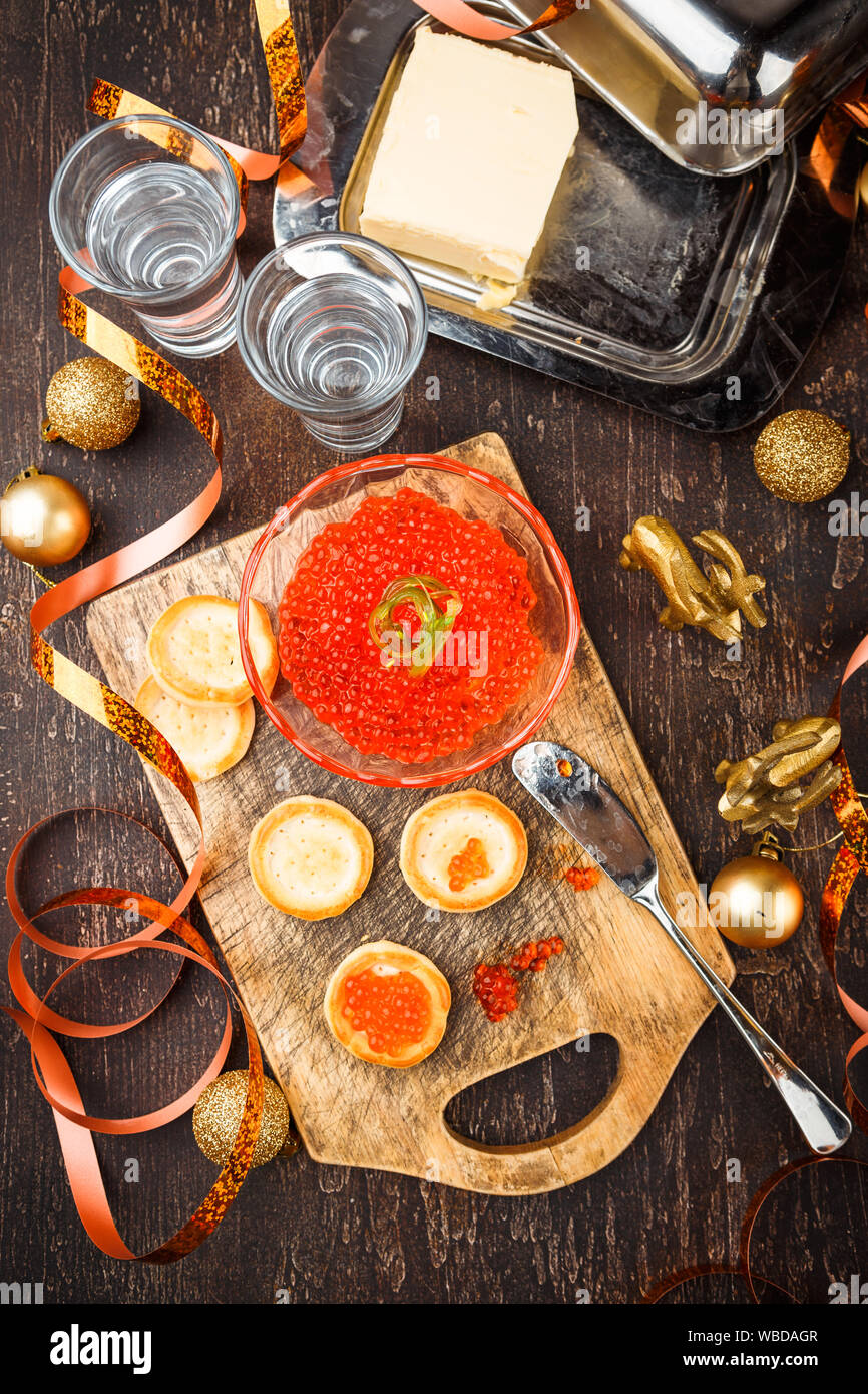 Tartlets with red caviar, champagne and butter on a festive table. Traditional Russian Christmas or New Year's holiday table. Top view. Space for text Stock Photo