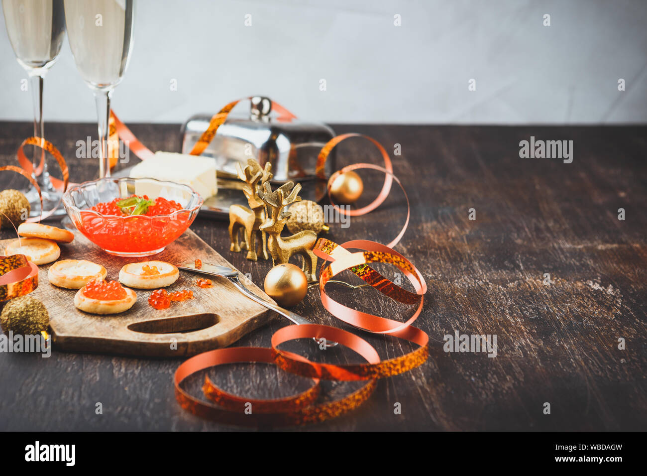 Tartlets with red caviar, champagne and butter on a festive table. Traditional Russian Christmas or New Year's holiday table. Space for text. Stock Photo