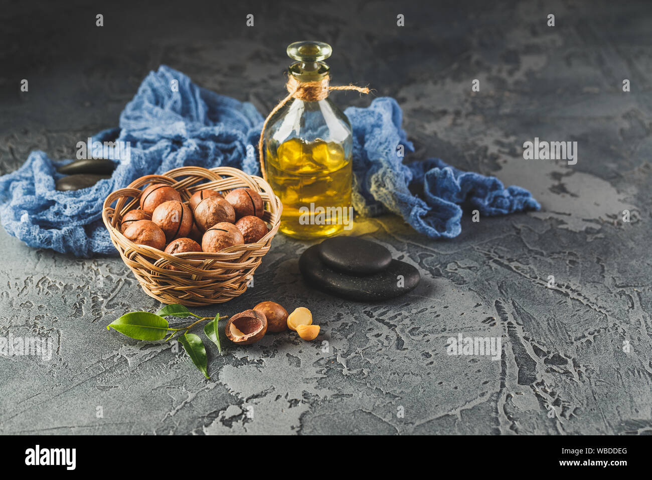 Glass bottles with Natural macadamia oil with macadamia nuts, sea salt and zen stones. Superfood and healthy food concept Stock Photo