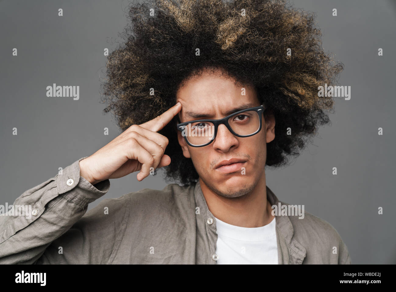 Image Of A Young Curly Displeased Teenage Guy Posing Isolated Over Grey 