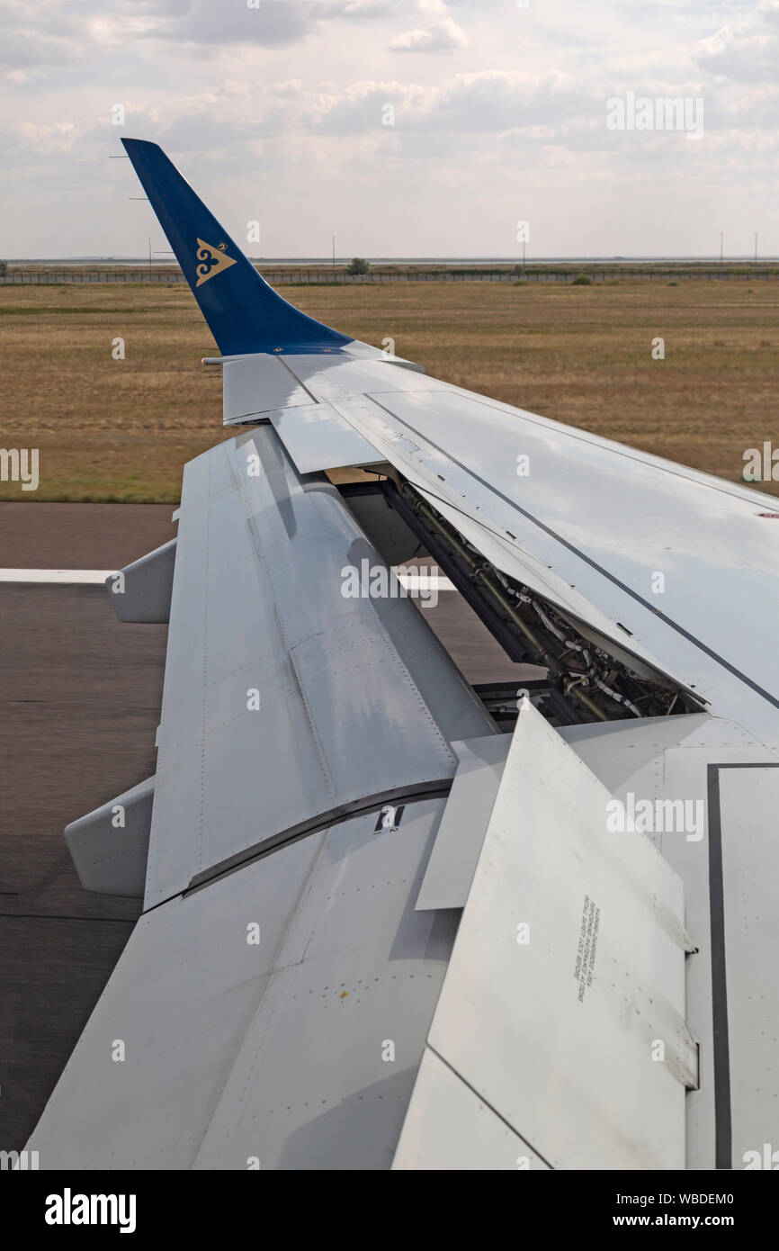 The wing of an Air Astana airliner as it lands at Nursultan Nazarbayev International Airport in  Kazakhstan. Stock Photo