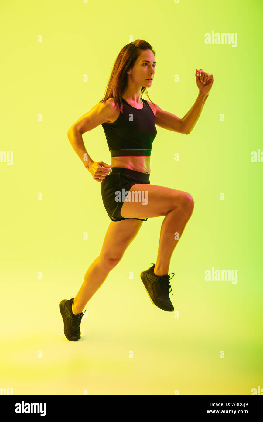 Full length of a beautiful young fitness girl working out isolated over