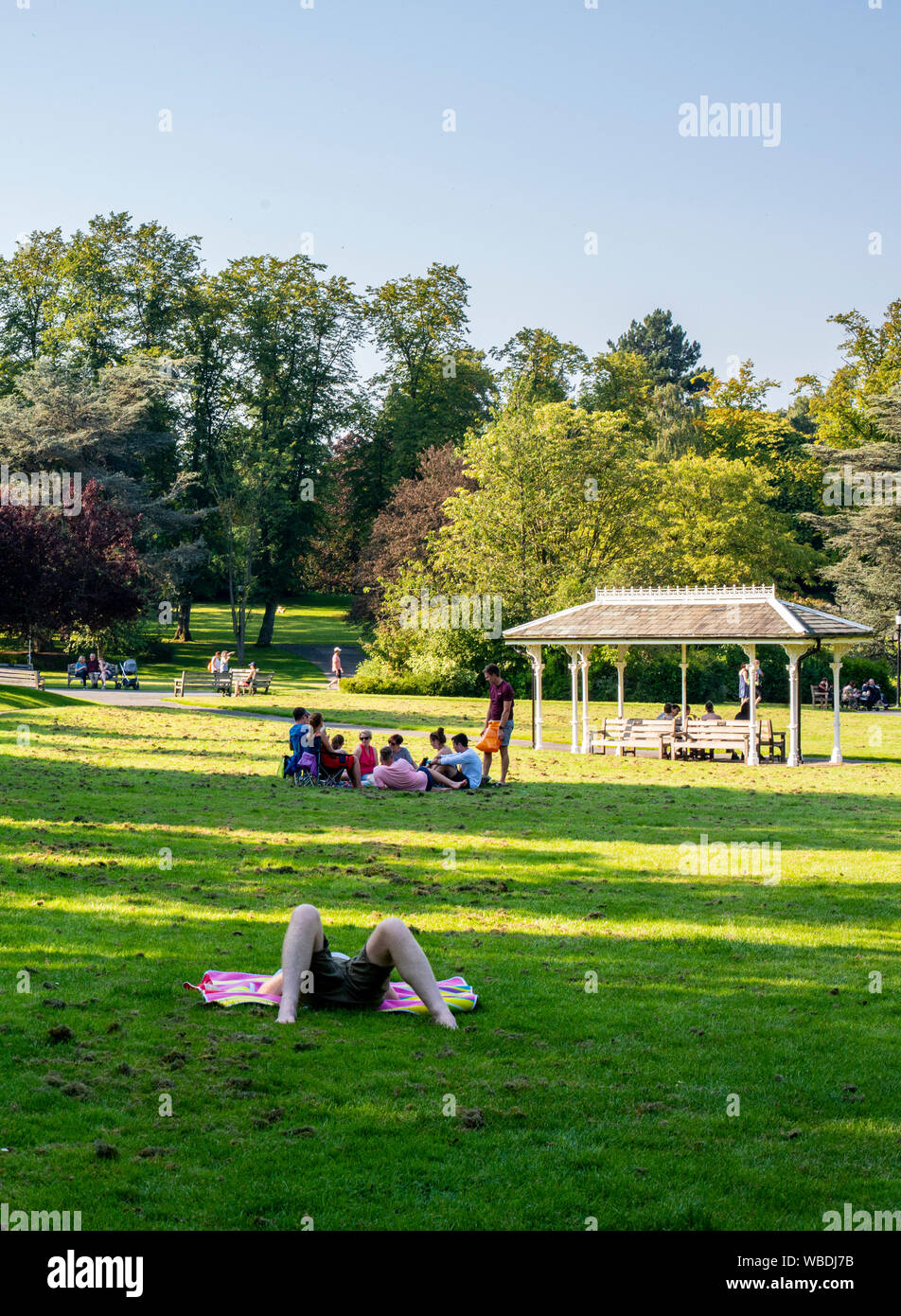 People relaxing on grass in park on very hot weather, Bank Holiday Monday, Valley Gardens, Harrogate, UK, 26 August 2019 Stock Photo