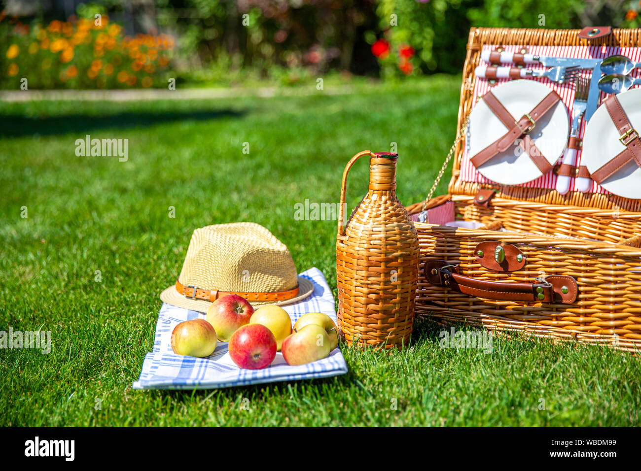 Picnic basket with food on green sunny lawn Stock Photo - Alamy