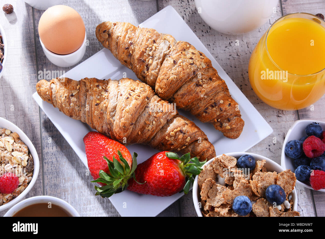 Breakfast served with coffee, orange juice, croissants, egg, cereals