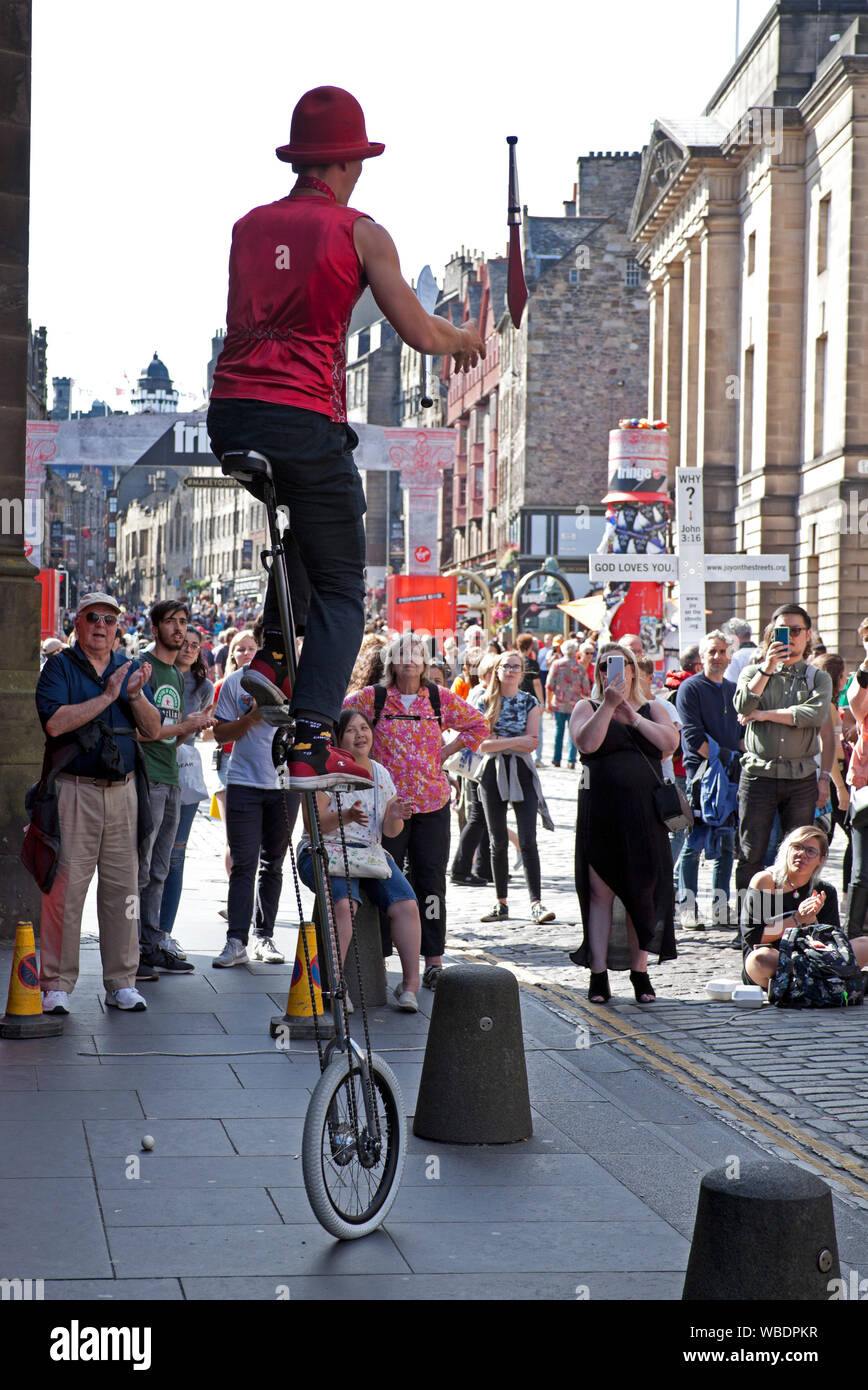 Edinburgh Fringe Festival, Scotland, UK. 26th Aug, 2019. Final day of the 2019 Edinburgh Fringe and the sun shone, with reported record breaking audiences and the most tickets sold ever. Hunter entertains a small audience juggling knives on his unicycle in the alcoves on the Royal Mile. Stock Photo