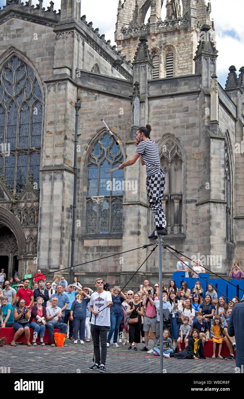 Edinburgh Fringe Festival, Scotland, UK. 26th Aug, 2019. Final day of the 2019 Edinburgh Fringe and the sun shone, with reported record breaking audiences and the most tickets sold ever. Pictured Ryhs the Trickster jugging fire torch and eating an apple. Stock Photo