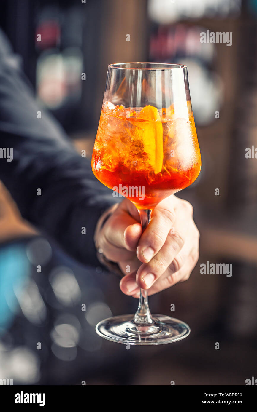 https://c8.alamy.com/comp/WBDR90/aperol-spritz-drink-bartender-hand-holding-glass-with-aperol-spritz-drink-WBDR90.jpg