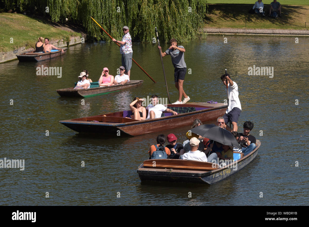 With record breaking August Bank Holiday temperatures visitors to Cambridge enjoy the weather by enjoying the river Cam in boats and Punts. Cambridge Stock Photo
