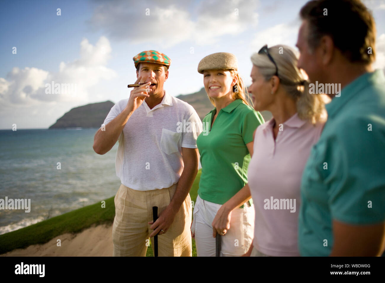 Male golfer smoking a cigar and a female golfer smile as they pose for