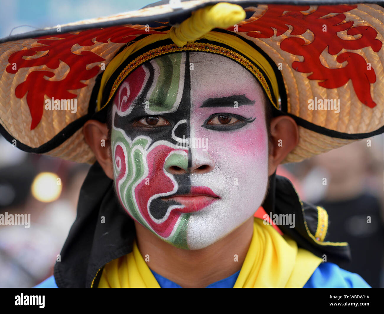 Costumed parade participant with traditional painted face at Bangkok’s colo...