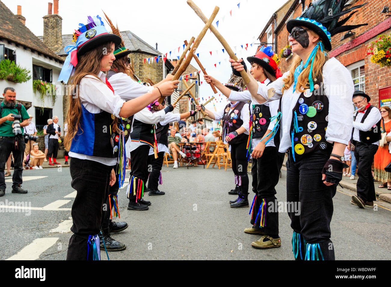 Sandwich folk and Ale Festival event in UK. The Broomdashers women's morris side with blacked faces and carrying wooden staffs, dancing in the street. Stock Photo