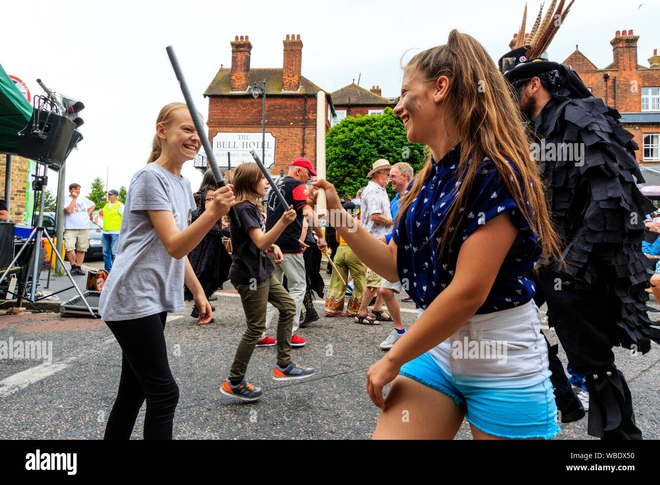 Sandwich folk and Ale Festival. Traditional morris dance outdoor workshop with people dancing in the street.Two young teenage girls dancing. Stock Photo