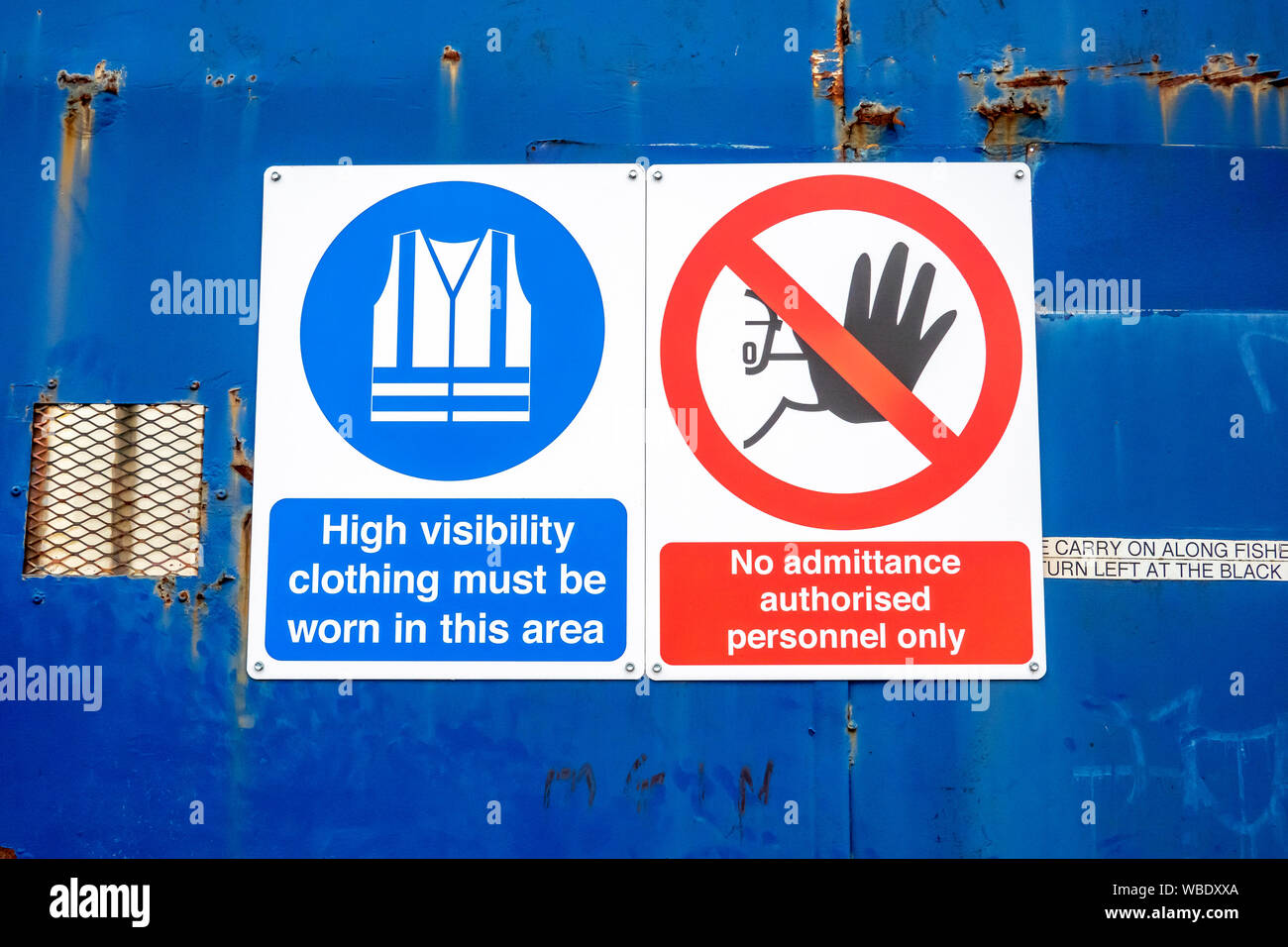 Healthy and safety information signs attached to blue metal doors Stock Photo