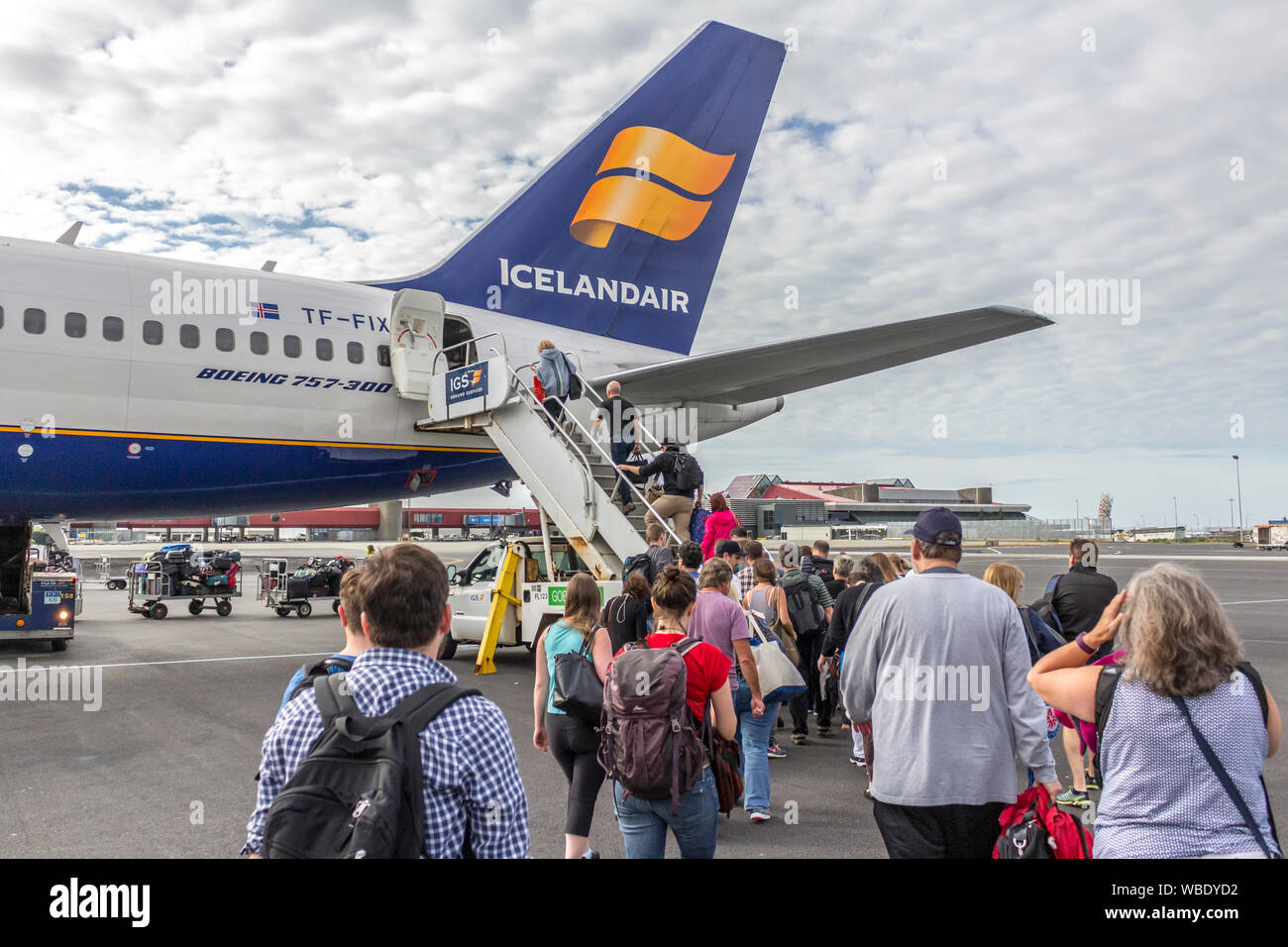 Airline passengers boarding a commercial jet on the tarmac in Iceland for a vacation or a trip home. Stock Photo