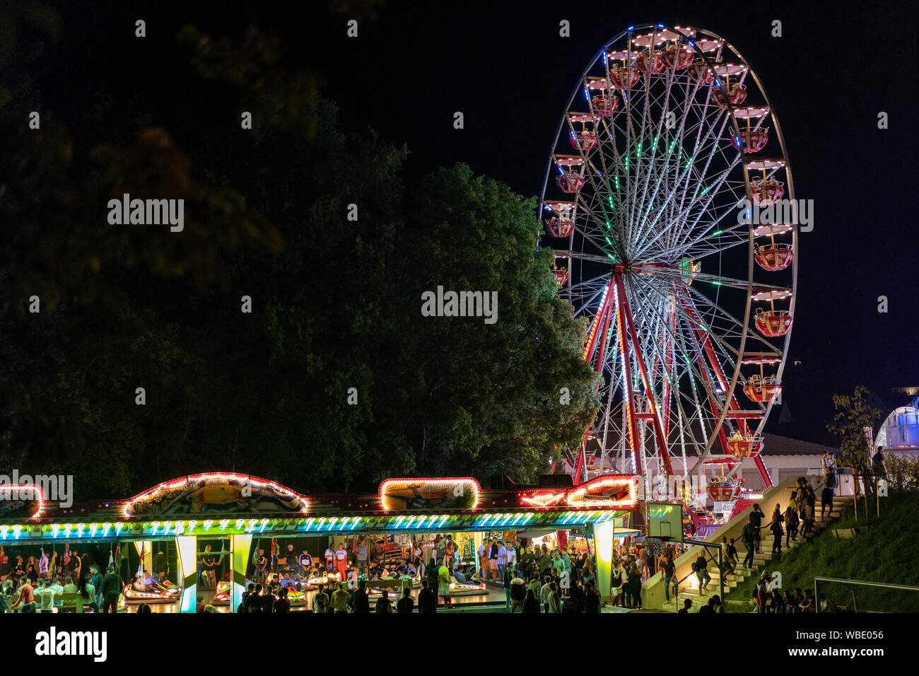 Stadtfest Brugg 24th of august 2019. street photography. Lunapark at night with illuminated spinning wheel and autosooter in Brugg. Stock Photo