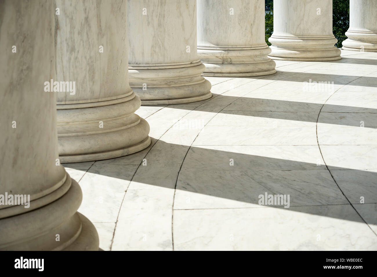 White marble neoclassical columns casting shadows in a rotunda Stock Photo