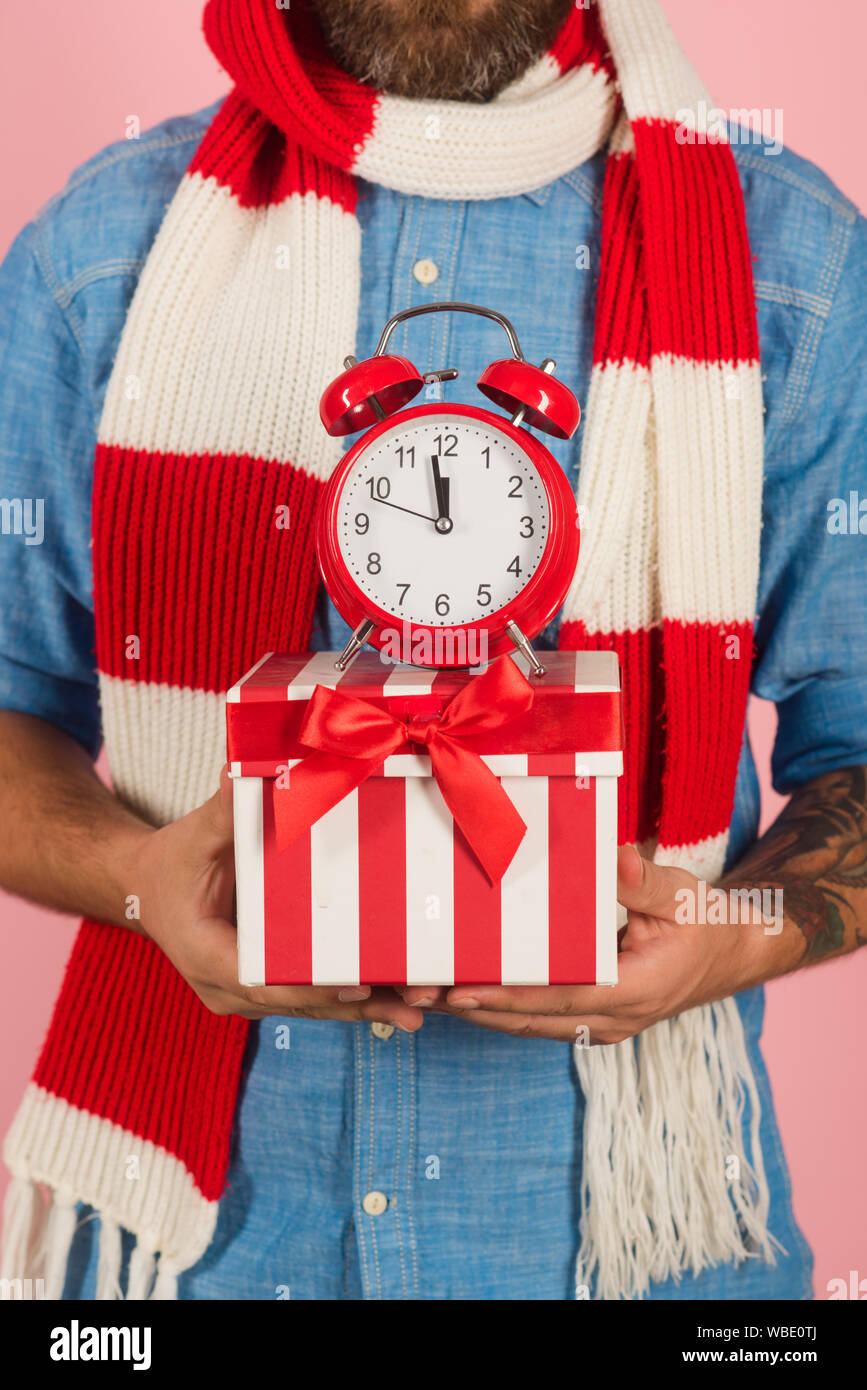 Christmas present box with red alarm clock in male hands Stock Photo