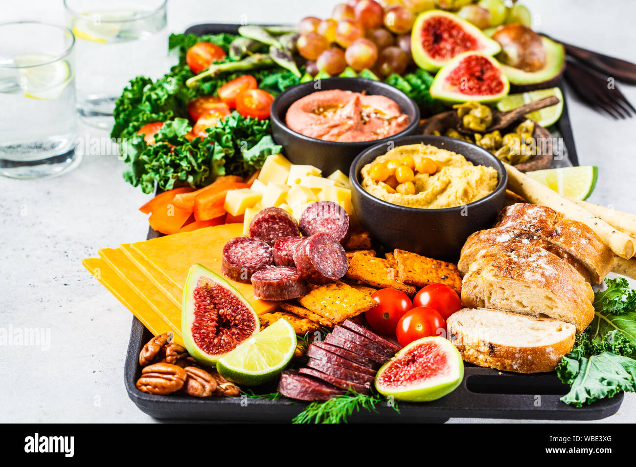 Meat and Cheese appetizer Platter. Sausage, cheese, hummus, vegetables, fruits and bread on a