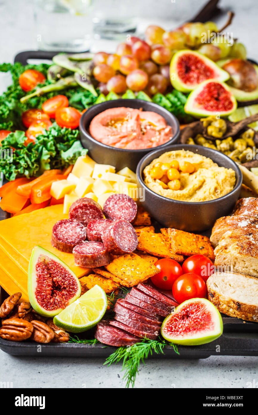 Meat and Cheese appetizer Platter. Sausage, cheese, hummus, vegetables, fruits and bread on a