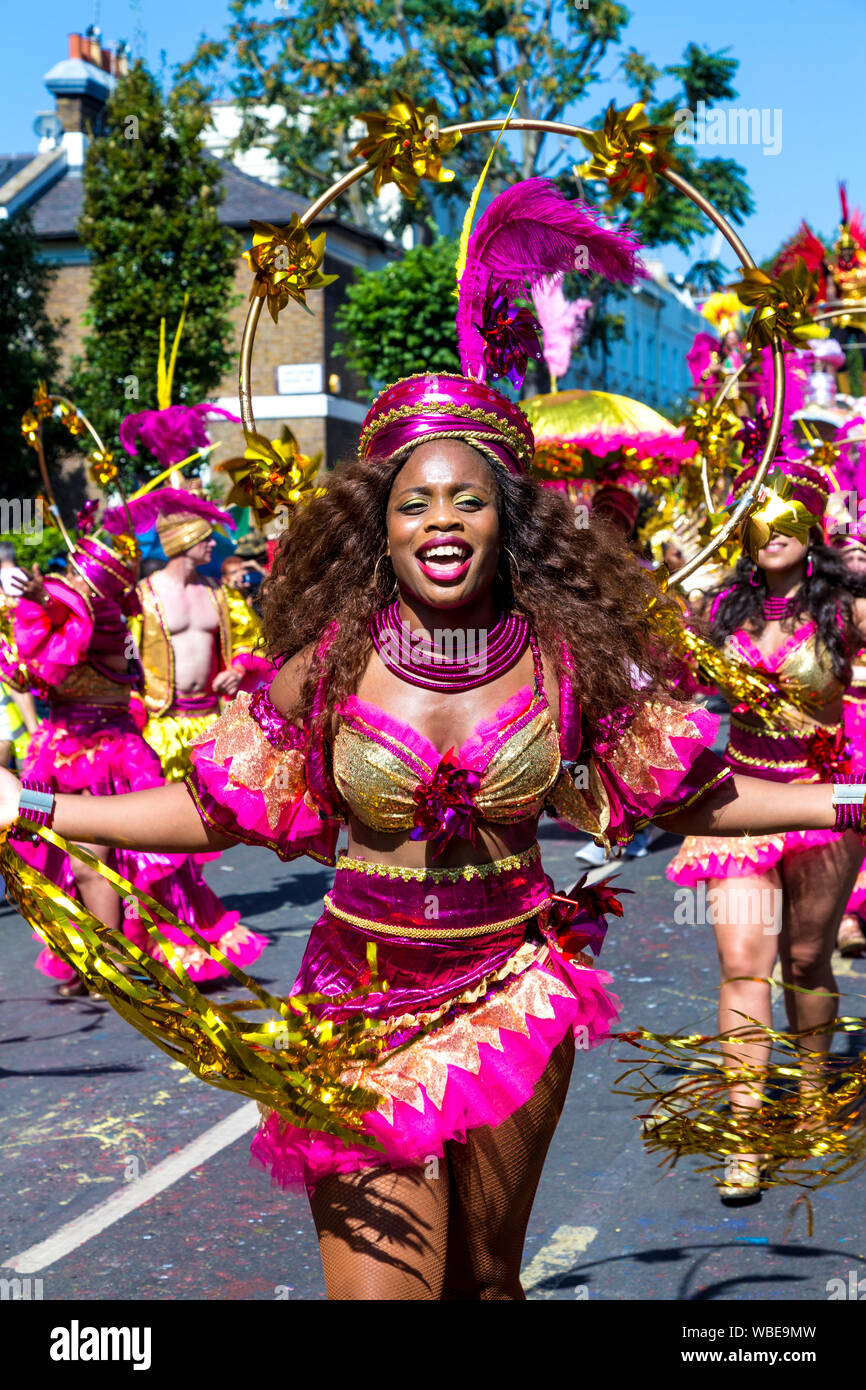 26 August 2019 - Woman dressed up in a pink and gold costume with hat and feather at Notting Hill Carnival on a hot Bank Holiday Monday, London, UK Stock Photo