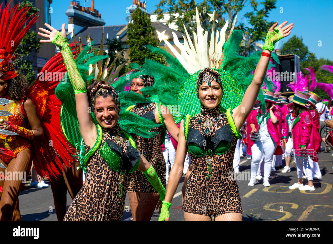 26 August 2019 - Women dressed up in feather collars and leopard print leotards waving, Notting Hill Carnival on a hot Bank Holiday Monday, London, UK Stock Photo