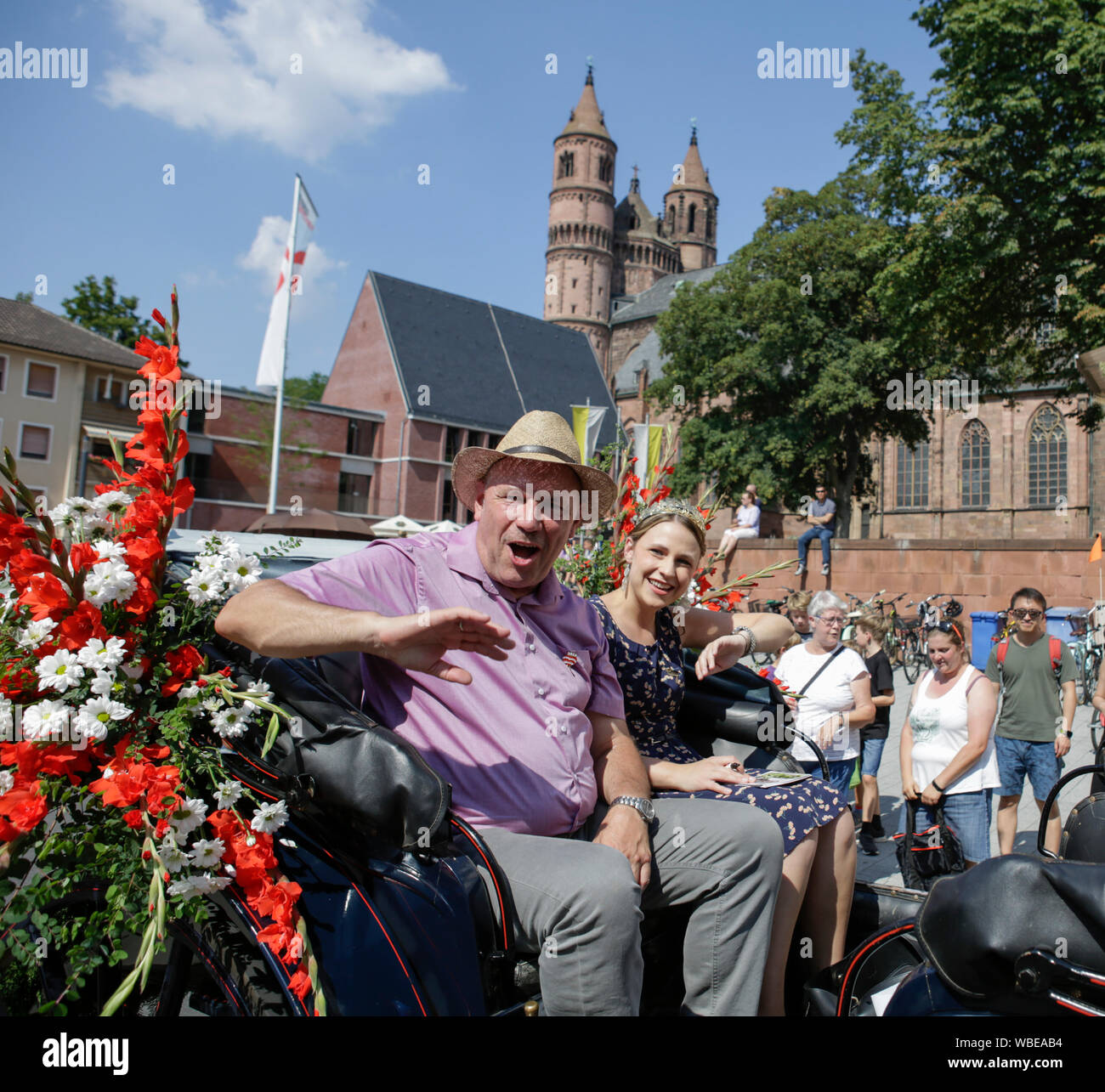 Worms, Germany. 25th August 2019. The Lord Mayor of Worms, Adolf Kessel, and the Rhine-Hessian wine queen Anna Göhring ride in an open horse-drawn carriage in the parade, waving to the crowd. The first highlight of the 2019 Backfischfest was the big parade through the city of Worms with over 70 groups and floats. Community groups, music groups and businesses from Worms and further afield took part. Stock Photo
