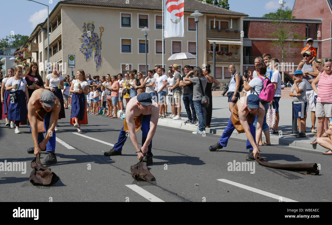 Worms, Germany. 25th August 2019. Local students perform the dance of the leather workers in the parade. The first highlight of the 2019 Backfischfest was the big parade through the city of Worms with over 70 groups and floats. Community groups, music groups and businesses from Worms and further afield took part. Stock Photo