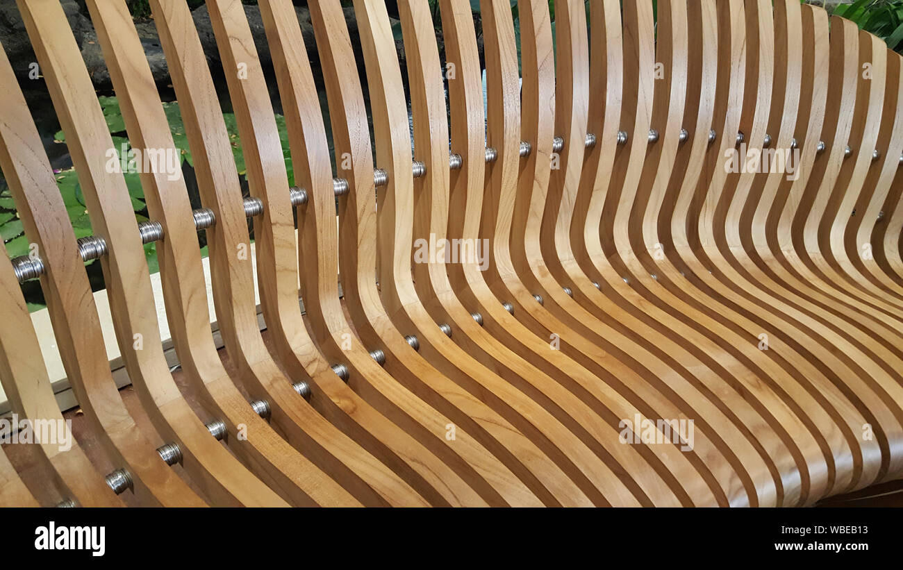 The geometry of modern furniture is demonstrated by the wooden slatted seat. Stock Photo