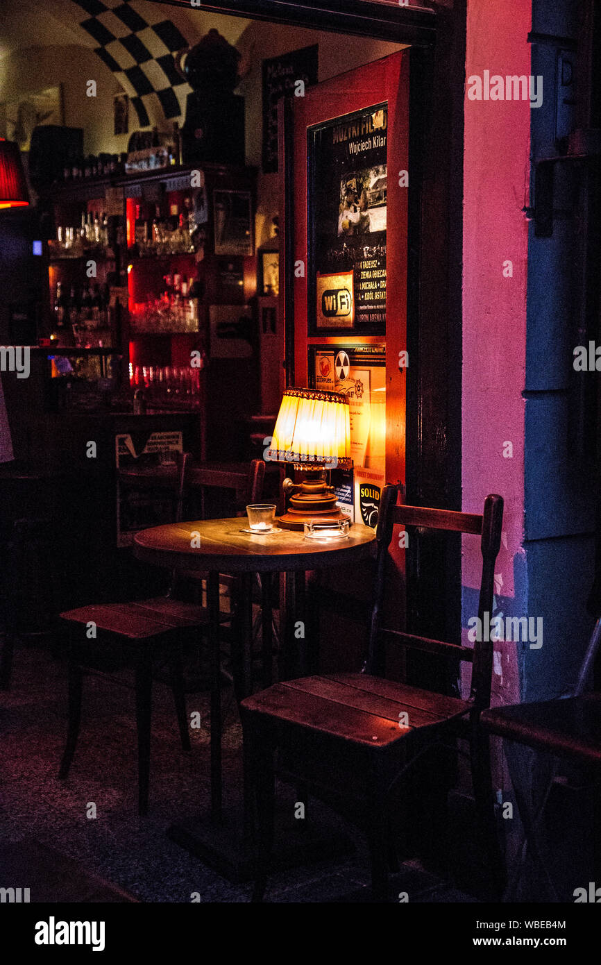 Table at Kawa i Papierosy cafe bar in the Jewish Quarter Kazimierz at night in Krakow, Poland Stock Photo