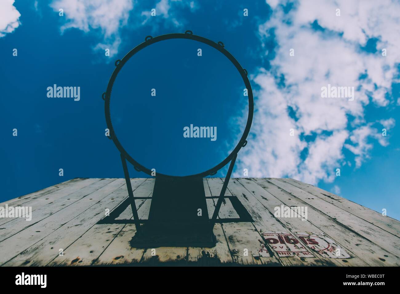 Low angle shot of a basketball hoop with a blue sky in the background Stock Photo