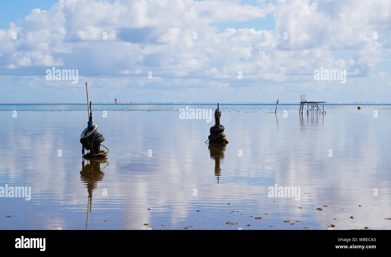 Still water in Kaneohe Bay, Hawaii reflects a unique pier at low tide. Stock Photo