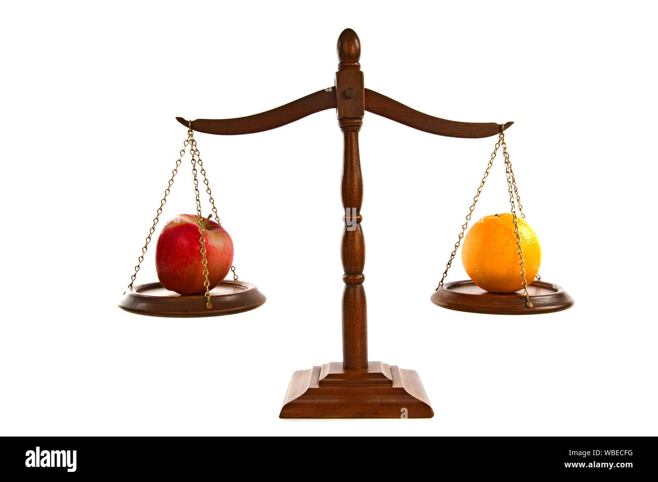 Horizontal shot of wooden scales of justice in balance.  There is an apple on one side and an orange on the other.  White background. Stock Photo